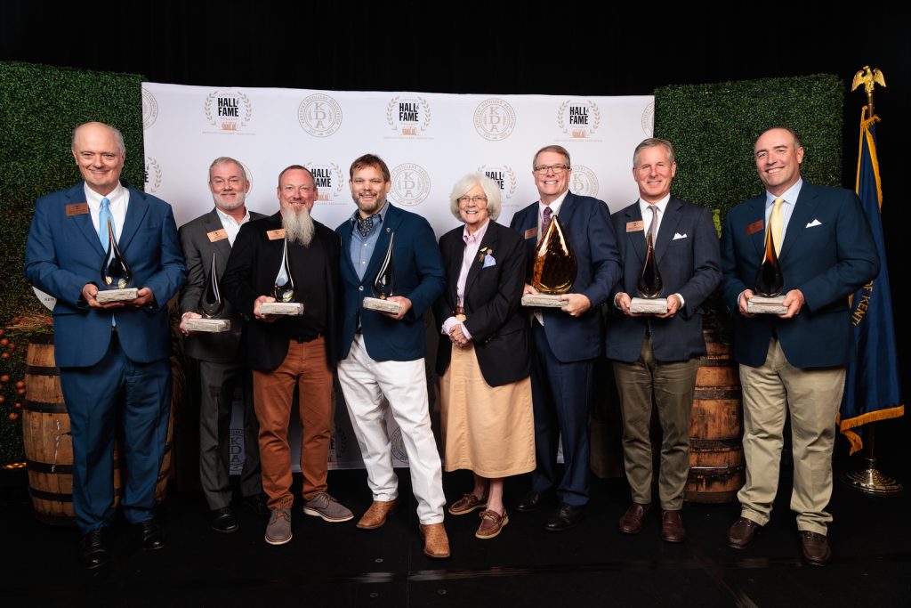 The 2026 Kentucky Bourbon Hall of Fame honorees and a family representative with their awards on stage