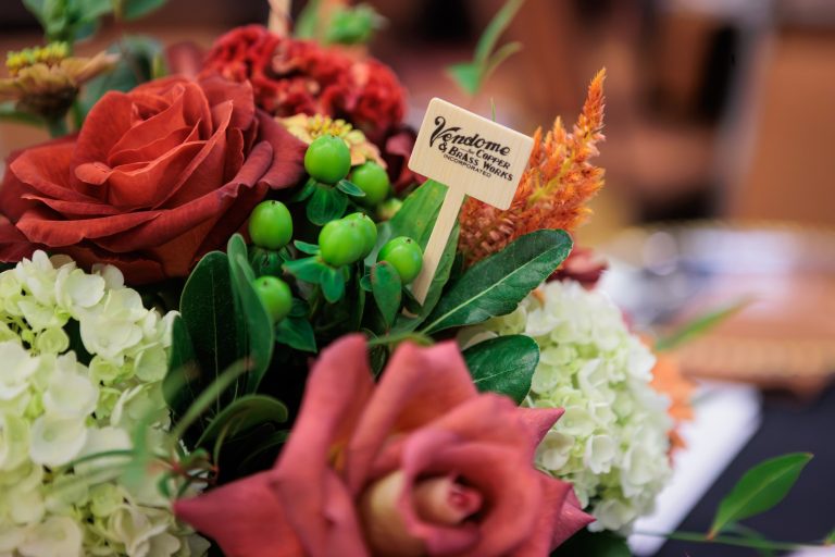 Table centerpiece at the 2026 Kentucky Bourbon Hall of Fame with a Vendome Copper & Brass Works sponsor pick among the roses