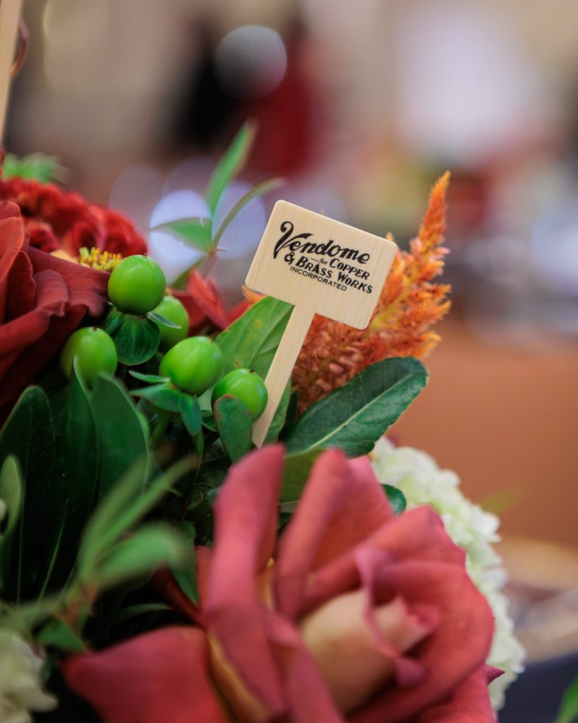 Close-up of a Vendome Copper & Brass Works pick in a floral centerpiece at the 2026 Kentucky Bourbon Hall of Fame luncheon